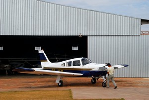 Vliegtuigje wordt uit de hangar gehaald